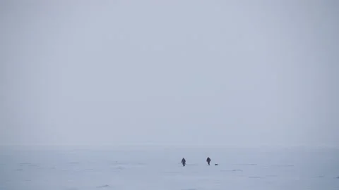 Panoramic view two people walking across the snow-covered Baltic sea 스톡 동영상 171310826
