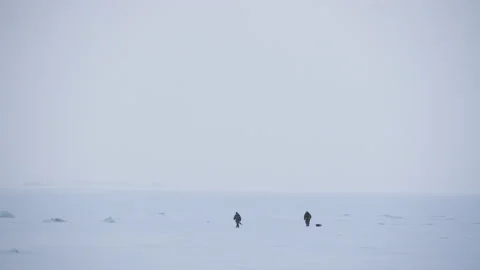 Panoramic view two people walking across the snow-covered Baltic sea 스톡 동영상 171311241