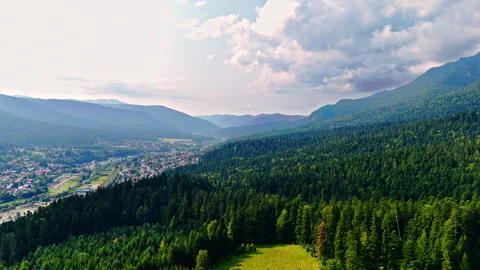 Panoramic view of valley town and forested hills. 스톡 동영상 321887566