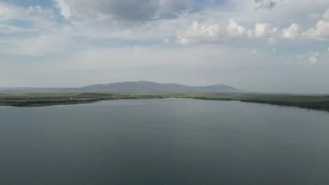 Panoramic view of a vast calm lake with distant hills under overcast sky. Stock Footage 341273956