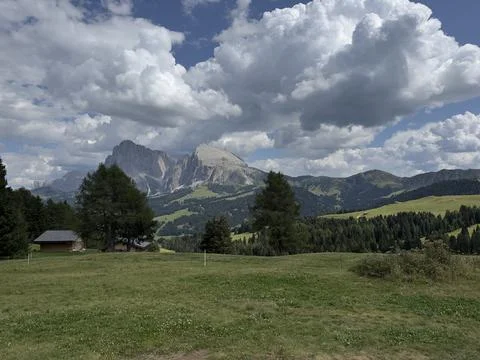 Panoramic view of vast green alpine meadow with iconic Dolomites mountain peaks Stock Photos
