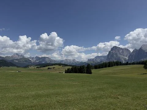 Panoramic view of vast green alpine meadow with iconic Dolomites mountain peaks Stock Photos