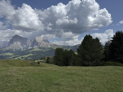 Panoramic view of vast green alpine meadow with iconic Dolomites mountain peaks Stock Photos