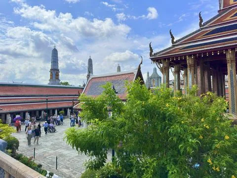 Panoramic view of Wat Phra Kaew courtyard with stupas and tourists visiting Stock Photos