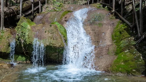 Panoramic view of a waterfall surrounded by moss-covered stones Vídeo Stock 150420176