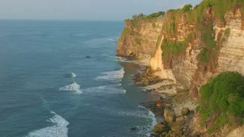 Panoramic View of Waves Crashing on Cliffs at Sunset in Uluwatu Bali Vídeos de archivo 339907540