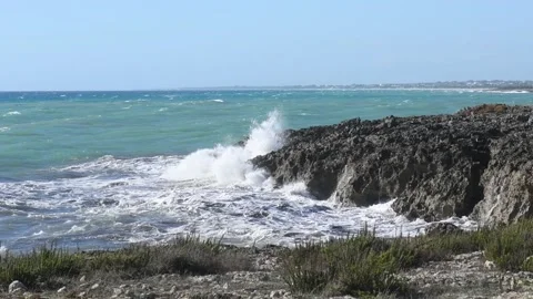 Panoramic view on waves dashing on a shore of black rocks in Puglia, Italy Stock Footage 131532466