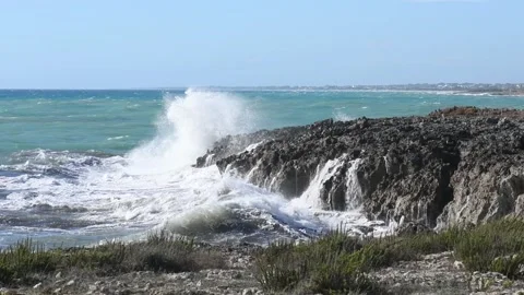 Panoramic view on waves dashing on a shore of black rocks in Puglia, Italy Stock Footage 131532525