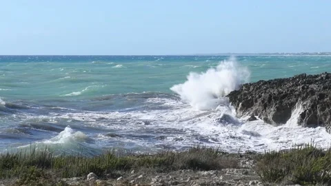Panoramic view on waves dashing on a shore of black rocks in Puglia, Italy Stock Footage 131532531