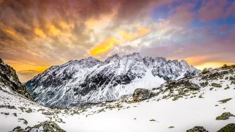 Panoramic view of white winter mountains after colorful sunset Stock Photos