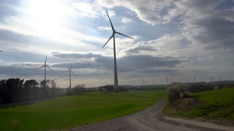 Panoramic view of wind farm or wind park on sunny day, with high wind turbines Stock Footage 184922891