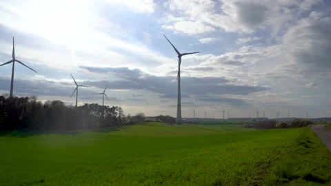 Panoramic view of wind farm or wind park on sunny day, with high wind turbines Stock Footage 184923127