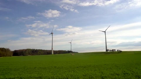 Panoramic view of wind farm or wind park on sunny day, with high wind turbines Stock Footage 184923882