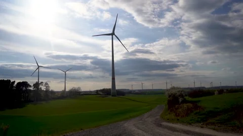 Panoramic view of wind farm or wind park on sunny day, with high wind turbines Stock Footage 188460691