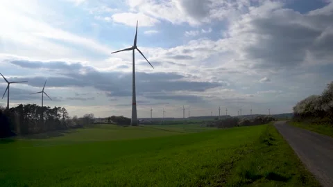 Panoramic view of wind farm or wind park on sunny day, with high wind turbines Stock Footage 188460968