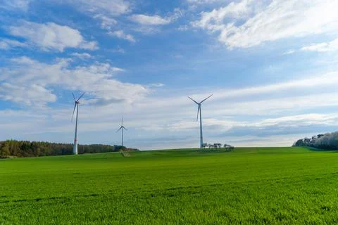 Panoramic view of wind farm or wind park on sunny day, with high wind turbines Stock Photos