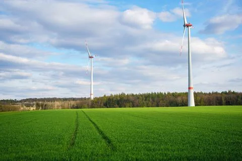 Panoramic view of wind farm or wind park on sunny day, with high wind turbines Stock Photos