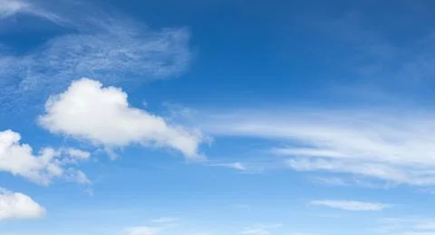 Panoramic white fluffy clouds in the blue sky Stock Photos