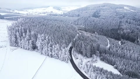 Panoramic winter drone view of the mountains in the forest. Asphalt road Vídeo Stock 231906938
