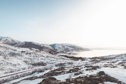 Panoramic winter view over a snowy Arctic fjord and mountain road in Northe.. Fotos Stock