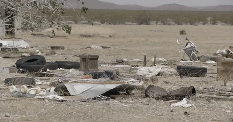 Pans Across Junk in Front Yard of Desert House Stock Footage 89943118