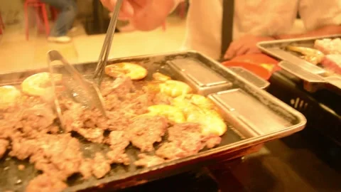 A pans full of meat in cook process for All You Can Eat stock footage Stock Footage 275167757