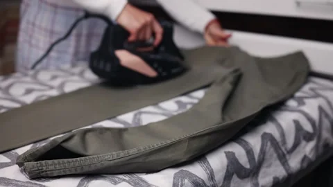 Pants on the table, in the background with an iron ironing the pants at home Stock Footage 242119052