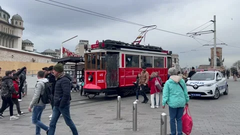 Paople Walking Next to the Red Tram in Taksim Square, Istanbul Stock Footage 237679935