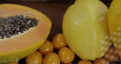 Papaya and lemon surrounded by small yellow fruits with animation text overlay Video stock 326427354