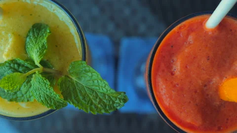 Papaya and mango smoothies with mint leaf on restaurant table Видео 233067755