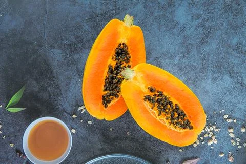 Papaya fruit on a blue stone table background. Slices of sweet papaya, Halv.. Stock Photos