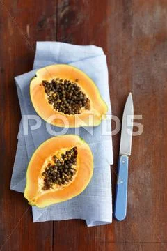 Papaya Halves On A Blue Linen Napkin