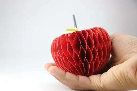 Paper apple with 3d effect made from color paper held in hand Stock Photos