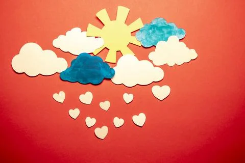Paper application - clouds with the sun from which white hearts are falling. Stock Photos