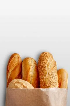 A paper bag with bread on the grey background. Stock Photos