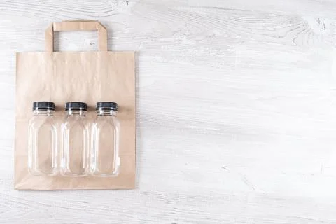 Paper bag, three plastic bottles. place for your logo. Eco-friendly food Stock Photos