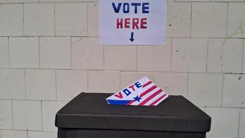 Paper ballot envelope being placed into black cardboard election voting box Foto stock