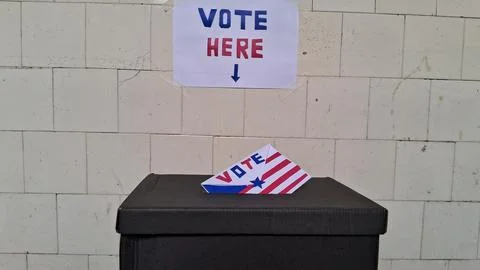 Paper ballot with flag patterns inserted into a black box container Stock Photos