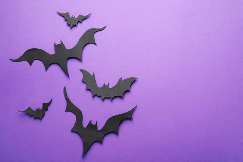 Paper bats and space for text on purple background, flat lay. Halloween decor Stock Photos