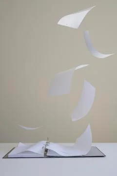 Paper blowing out of ring binder and floating in mid-air Foto stock