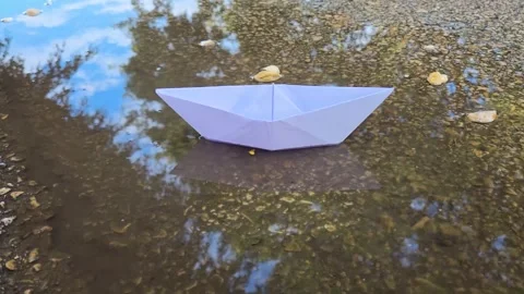 Paper boat floats in a puddle. Video: Rain, rainy weather, flood, autumn, winter Stock Footage 324627131