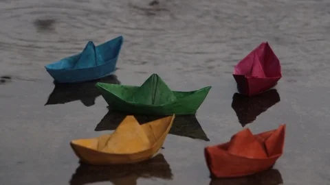 Paper boats in a puddle in the rain Stock Footage 85388188