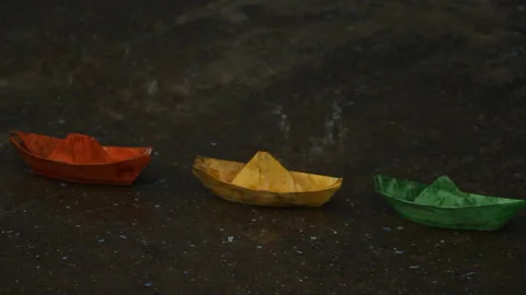 Paper boats in a puddle in the rain Stock Footage 107040448
