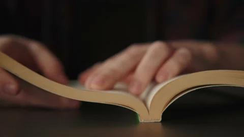 Paper book on the table, a man reads literature, turns a page. Video stock 162755460