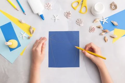 Paper bucket of shells summer idea for kids craft in kindergarten hands ocean's Stock Photos
