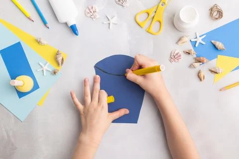 Paper bucket of shells summer idea for kids craft in kindergarten hands ocean's Stock Photos