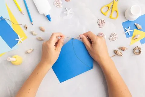 Paper bucket of shells summer idea for kids craft in kindergarten hands ocean's Stock Photos