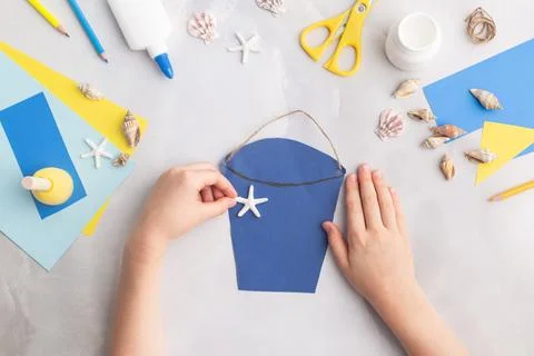 Paper bucket of shells summer idea for kids craft in kindergarten hands ocean's Stock-Fotos