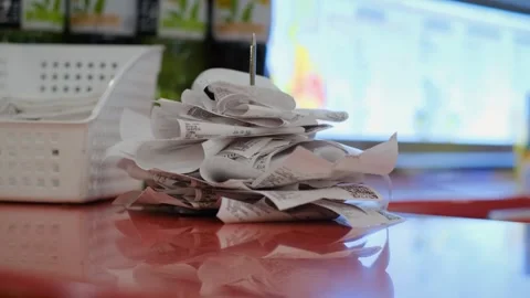 Paper checks or customer orders are pinned on a table needle Stock Footage 246980446