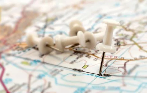 A paper clip on the map shows the end point of the route. Travel guide. Map Stock Photos